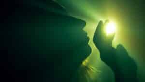A silhouette of a person reaching for a mystical light source, creating an ethereal ambiance.
